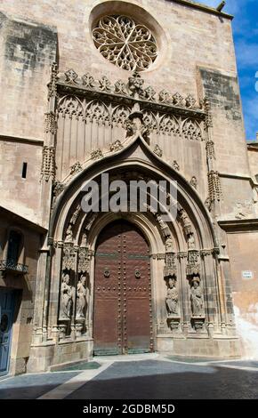 Ein Blick auf eine schöne, gewölbte Tür an der alten Kathedrale von Murcia. Dekorative, gotische, geschnitzte Bögen umrahmen die schwere, mittelalterliche alte Tür Stockfoto