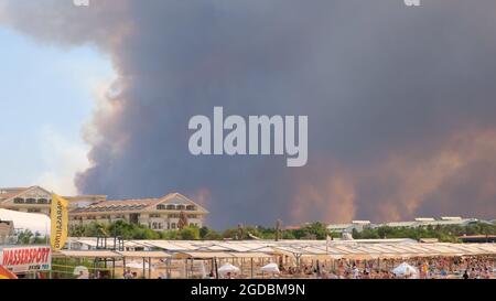 Flammen und Rauch von Waldbränden bedecken die Landschaft. Rauchwolken über Hotels und über dem Meer: Antalya, Manavgat Türkei - 28. Juli 2021. Stockfoto