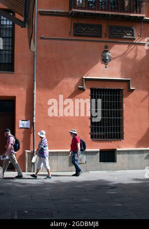 Granada / Spanien / 10-11-2019: Touristen gehen an einem schönen alten Gebäude an der Plaza Bib Rambla an einem späten Sommertag vorbei. Stockfoto