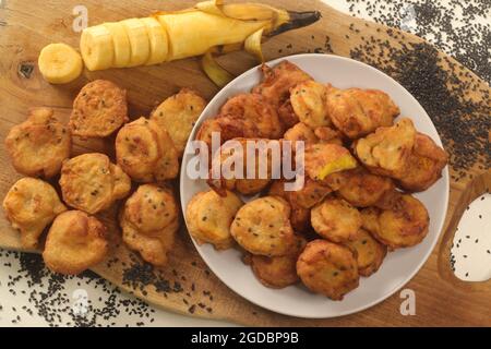 Krapfen aus Kochbananen. Kochbananen in Vollkornmehl getaucht und in Kokosöl frittiert. Kerala Special genannt ethakka appam. Stockfoto