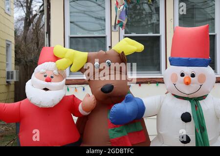 Aufblasbarer Weihnachtsmann, Rentier und Schneemann vor dem Haus Stockfoto