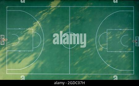 Sports football field, playground with green grass. Shade from trees on football soccer field in the morning. Stockfoto