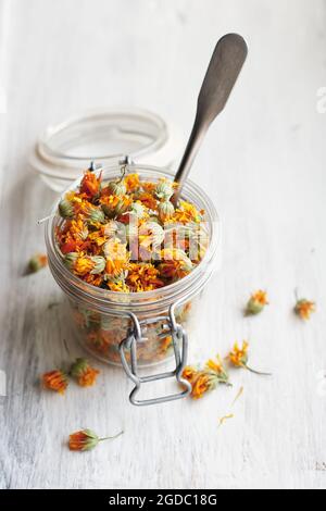 Getrocknete Ringelblumen in einem Glas auf weißem Holz. Stockfoto