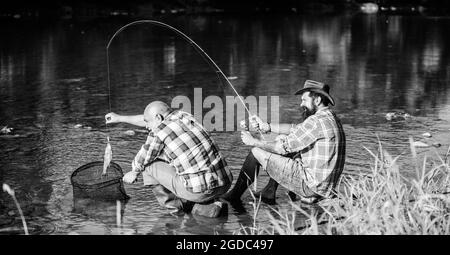 Schwarzmarkt Kaviar. Wilderer, die fischen. Falle für Fische. Männer sitzen am Flussufer mit Angelausrüstung. Illegale Jagd Kaviar. Extrahiert Eier aus Stör Stockfoto