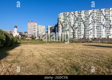 St. Petersburg, Russland-circa Jun, 2021: Das Mikroviertel Kudrovo mit dem Okkervil-Park und neuen Gebäuden mit einer Kirche, Leningrad Stockfoto