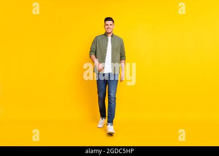 In voller Länge Körpergröße Foto Kerl zu Fuß nach vorne isoliert lebendige gelbe Farbe Hintergrund Stockfoto