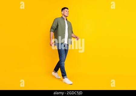 In voller Länge Körpergröße Foto Kerl zu Fuß vorwärts schauende Copyspace isoliert lebendige gelbe Farbe Hintergrund Stockfoto