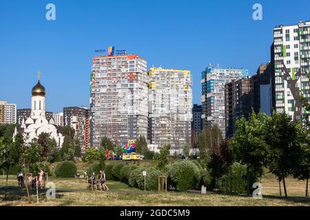 St. Petersburg, Russland-circa Jun, 2021: Das Mikroviertel Kudrovo mit dem Okkervil-Park und neuen Gebäuden mit einer Kirche, Leningrad Stockfoto