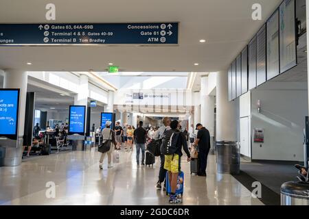 Reisende, die durch den Flughafen LAX in Los Angeles laufen Stockfoto