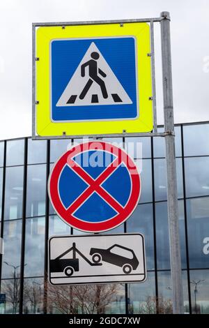 Fußgängerüberweg und kein Parkschild mit Schild, auf dem über das Arbeiten des Abschleppwagens informiert wird Stockfoto