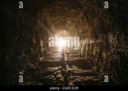 Dunkler und gruseliger alter historischer gewölbter unterirdischer Straßentunnel. Stockfoto