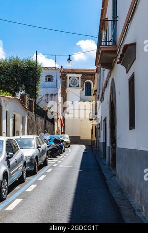 Sorrento, Italien - August 26 2020: Blick auf die schmale Straße voller Autos mit Uhrenturm am Ende Stockfoto