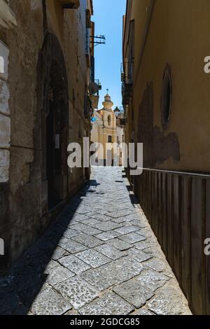 Sorrento, Italien - August 26 2020: Schmale Straße mit Kirchengebäude am Ende mit kleiner Kuppel Stockfoto