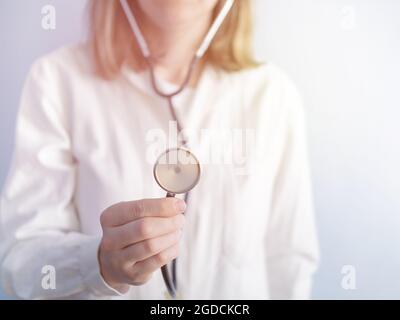 Porträt einer Ärztin, die Herz und Atmung hört, Stethoskop setzt, Foto Stockfoto