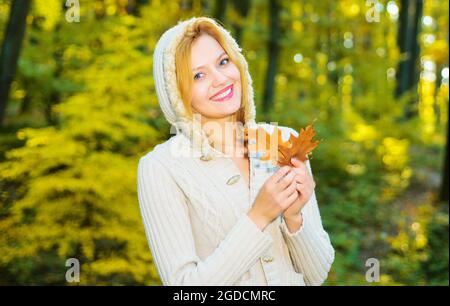 Schönes Mädchen zu Fuß im Herbst Park. Lächelnde Frau mit gelben Blättern. Weibchen genießen Herbstwetter. Sonniger Tag. Stockfoto