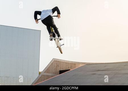 Ein junger Fahrer auf einem BMX-Fahrrad macht Tricks in der Luft. BMX Freestyle in einem Skatepark. Stockfoto