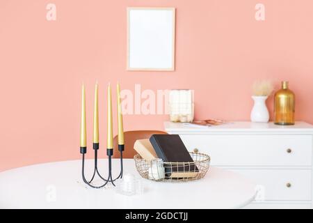 Duftkerzen und Bücher auf dem Tisch im Zimmer Stockfoto