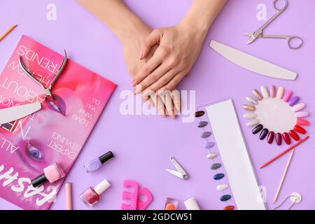 Weibliche Hände, professionelle Werkzeuge für die Maniküre und Magazin auf farbigem Hintergrund Stockfoto