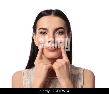 Junge Frau macht Gesichtsaufbau Übung vor weißem Hintergrund Stockfoto