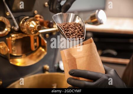 Mann verpackt Kaffeebohnen nach dem Rösten Stockfoto