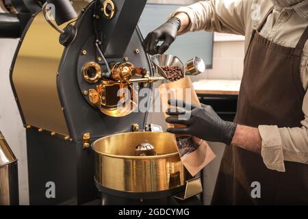 Mann verpackt Kaffeebohnen nach dem Rösten Stockfoto