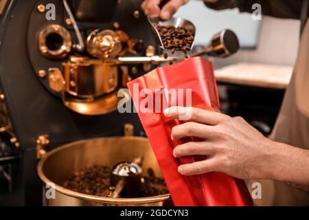 Leitender Mann verpackt Kaffeebohnen nach dem Rösten Stockfoto