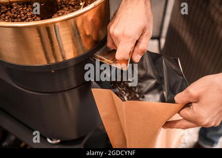 Leitender Mann verpackte Kaffeebohnen nach dem Rösten, Nahaufnahme Stockfoto