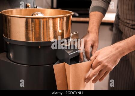Leitender Mann verpackte Kaffeebohnen nach dem Rösten, Nahaufnahme Stockfoto