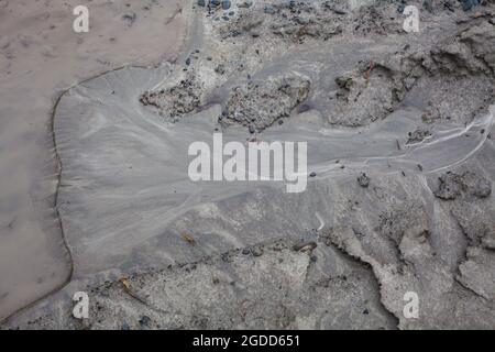 Mikroskalige geografische Merkmale im Schlamm nach einer Flußflut. Die Landschaft sieht aus wie Satellitenbilder, mit Schluchten, Flusstälern, Deltas und Schluchten. Stockfoto