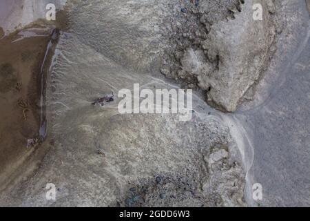 Mikroskalige geografische Merkmale im Schlamm nach einer Flußflut. Die Landschaft sieht aus wie Satellitenbilder, mit Schluchten, Flusstälern, Deltas und Schluchten. Stockfoto