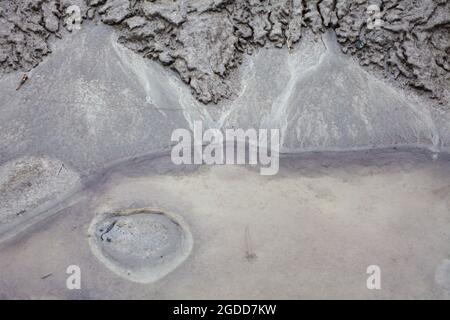 Mikroskalige geografische Merkmale im Schlamm nach einer Flußflut. Die Landschaft sieht aus wie Satellitenbilder, mit Schluchten, Flusstälern, Deltas und Schluchten. Stockfoto