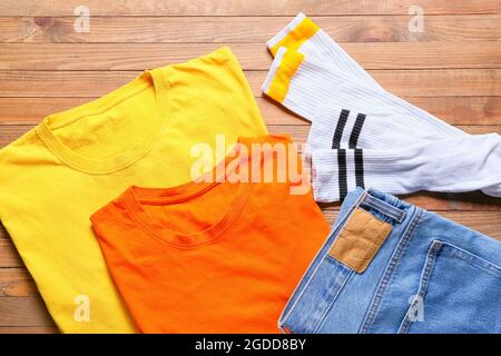 T-Shirts, Jeans und Socken auf Holzhintergrund Stockfoto