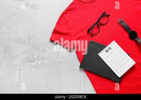 Komposition mit stilvollem T-Shirt, Kalender, Notizbuch und Accessoires auf hellem Hintergrund Stockfoto