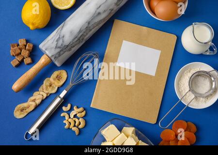 Rezeptbuch mit Produkten auf farbigem Hintergrund Stockfoto