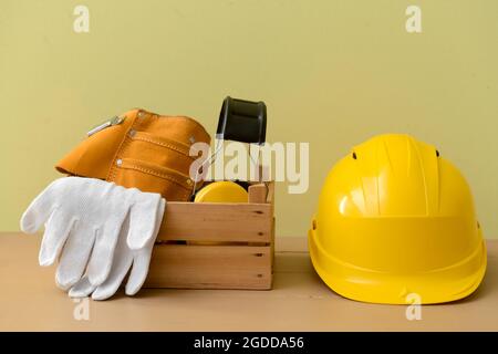 HardHat mit Baumaterial auf farbigem Hintergrund Stockfoto