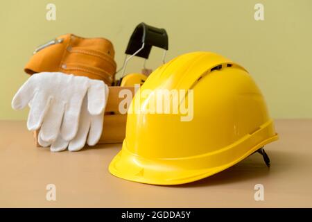 HardHat mit Baumaterial auf farbigem Hintergrund Stockfoto