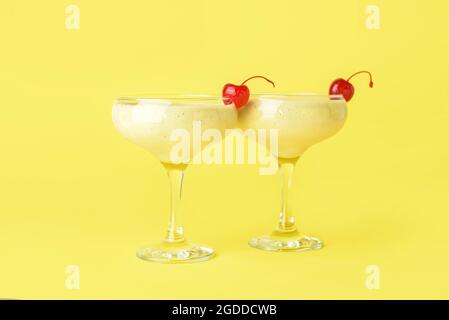 Gläser mit leckeren Bananen-Daiquiri-Cocktail auf farbigem Hintergrund Stockfoto