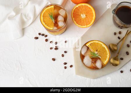 Gläser leckerer Kaffee mit Orangensaft und Früchten auf hellem Hintergrund Stockfoto