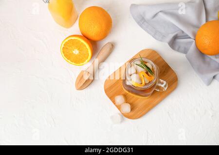 Einmachglas mit leckerem Kaffee mit Orangensaft und frischen Früchten auf hellem Hintergrund Stockfoto