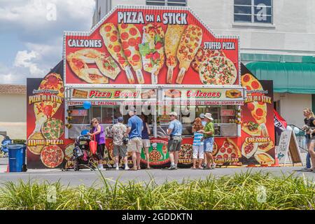 Florida Brooksville Florida Blueberry Festival Schlange stehen, Karneval Lebensmittelhändler Stand Stand Pizza auf einem Stock Kunden, Stockfoto