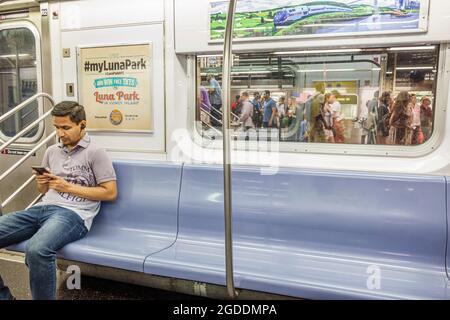 NY, NYC, New York City, Lower Manhattan U-Bahn, MTA IRT Lexington Avenue Line Stop Station Asian Mann, Smartphone Handy überprüfen suchen Lesen t Stockfoto