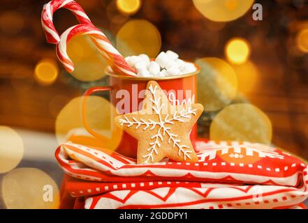 Heißer Weihnachtsdrink in einer Tasse vor funkelnden Lichtern. Urlaub Stockfoto