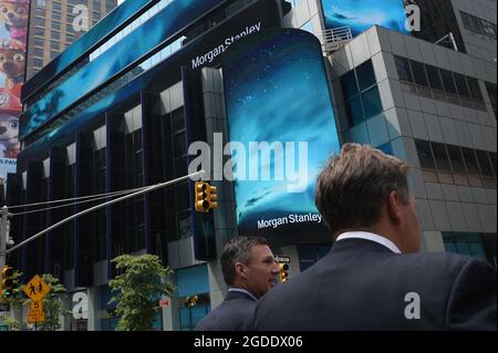 New York City, USA. August 2021. Zwei Männer laufen am Hauptsitz von Morgan Stanley nahe dem Times Square vorbei, als das Investmentbanking-Unternehmen bekannt gab, dass seine Mitarbeiter den COVID-19-Impfstoff erhalten müssen, bevor sie am 10. August 2021 in ihre New Yorker Büros in New York, New York, NY, zurückkehren. Der Schritt, die Impfungen von Mitarbeitern zu verlangen, folgt auf die Delta-Variante, die in den Vereinigten Staaten einen starken Anstieg von Coronavirus-Infektionen verursacht. (Anthony Behar/Sipa USA) Quelle: SIPA USA/Alamy Live News Stockfoto