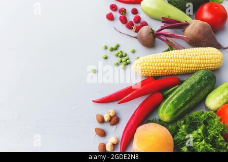 Flach legen mit verschiedenen Gemüse, Früchten, Beeren, Nüssen, Gewürzen, Kräuter, Olivenöl. Bereich für Textbereich kopieren. Gemüse auf grauem Betonboden Stockfoto