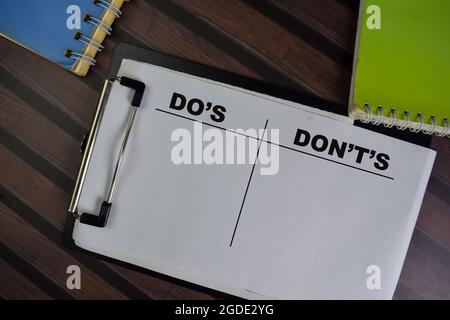 Do's und Don't's schreiben auf einen Papierkram isoliert auf Holztisch. Stockfoto
