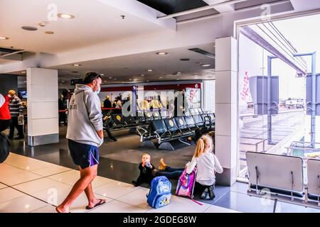 Melbourne, Australien. Mai 2021. Ein Mann mit zwei Kindern wird während eines Boarding-Anrufs am Inlandsterminal des Flughafens Melbourne in der Abflughalle gesehen. (Foto: Alexander Bogatirev/SOPA Image/Sipa USA) Quelle: SIPA USA/Alamy Live News Stockfoto