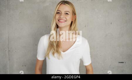 Entzückte Frau in der Nähe einer Betonwand Stockfoto