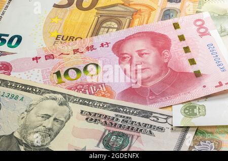 Nahaufnahme von bis zu hundert Yuan der Volksrepublik China mit Banknoten zwischen 50 US-Dollar und 50 Euro. 100 Renminbi-Banknoten. Handelskrieg. Geld o Stockfoto