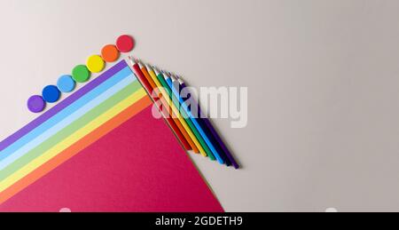 Pastellpapier, Bleistifte und Regenbogenfarben auf beigem Hintergrund. Waren für Kreativität, flaches Layout, Kopierraum Stockfoto