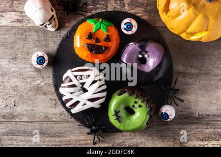 Assortmen von Halloween Donuts auf Holztisch Stockfoto